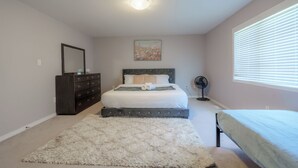A bedroom with a bed, dresser, and a painting on the wall. - Luxury 4BR Getaway|Mins to Falls & Casino|Sleeps 9 (Niagara Falls)