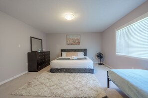 Ein Schlafzimmer mit Bett, Kommode und einem Bild an der Wand.