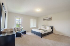 A bedroom with a bed, a desk, a chair, a window, and a painting on the wall. - Luxury 4BR Getaway|Mins to Falls & Casino|Sleeps 9 (Niagara Falls)