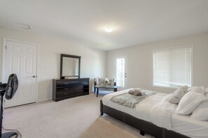 A bedroom with a bed, dresser, chair, and a fan. - Luxury 4BR Getaway|Mins to Falls & Casino|Sleeps 9 (Niagara Falls)