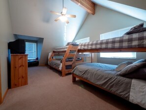 A dormitory room with bunk beds, a ceiling fan, a television, and a window with blinds. - Family Cabin with Beautiful view of Bear Lake (Garden City)