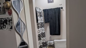 Ein Badezimmer mit Toilette, Duschvorhang und Handtuchhalter.