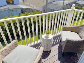 Ein Balkon mit Korbmöbeln und einer Topfpflanze.