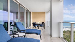 A balcony with wicker furniture, a table, and a view of the beach. - Marriott's Crystal Shores : Two bedroom villa, gulf front, 7 nights (Marco Island)