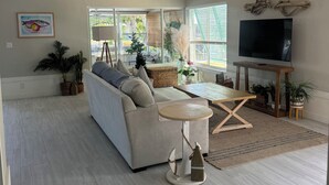 Uma sala de estar moderna com sofá, mesa de centro e ventilador de teto.