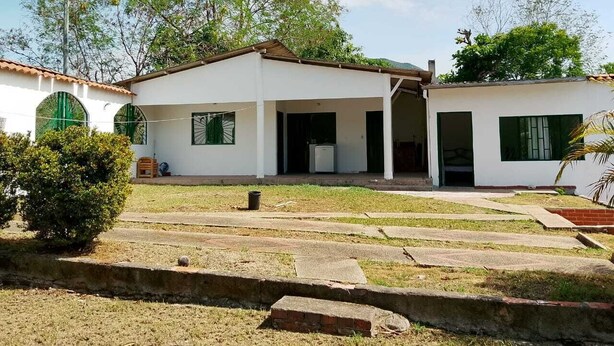 A single-story house with a flat roof, a front porch, and a small front yard. - Girardot Vacation Rental: Your Relaxation Guaranteed (Cundinamarca)