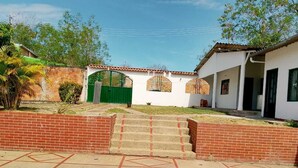 A swimming pool with steps leading up to a house with a green gate and a white exterior. - Girardot Vacation Rental: Your Relaxation Guaranteed (Cundinamarca)