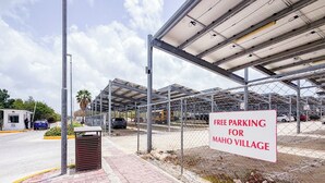 Ein Parkplatz mit Schild, das kostenloses Parken in Maho Village anzeigt.