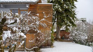 A wooden building with a snow-covered roof and a snow-covered pathway leading to it. - Le Bi-Fûts - ALLEVARD (ALLEVARD)