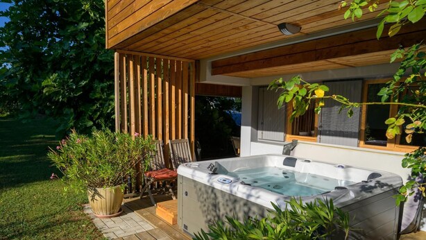 A wooden deck with a hot tub, outdoor seating, and potted plants. - Le Bi-Fûts - ALLEVARD (ALLEVARD)