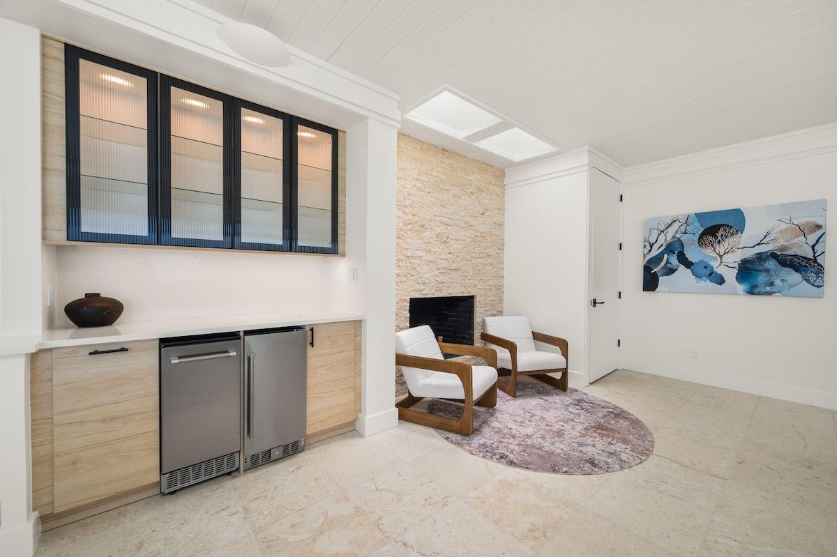 Un salon moderne avec une cheminée, un coin salon et des œuvres d’art accrochées au mur.