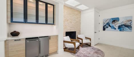 Ein modernes Wohnzimmer mit Kamin, Sitzecke und Kunstwerken an der Wand.