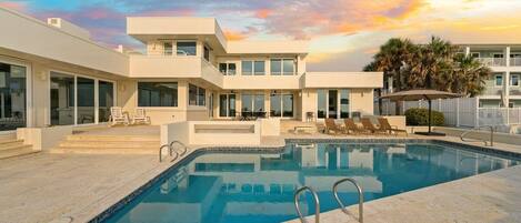 A modern pool area with a clear sky and a sunset.