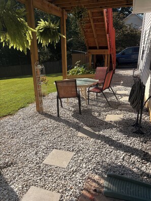 A patio area with a pergola, outdoor seating, and a gravel ground. - Cozy 1-bedroom house in superb Conyers with AC (Conyers)