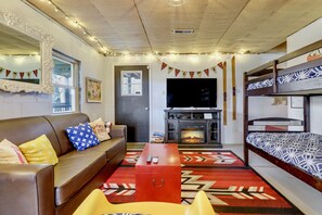 Ein gemütliches Wohnzimmer mit einem braunen Sofa, einem roten Couchtisch und einem gemusterten Teppich.