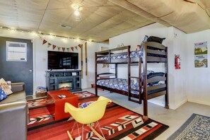Una stanza con letti a castello, televisione, camino e un tappeto rosso decorato.