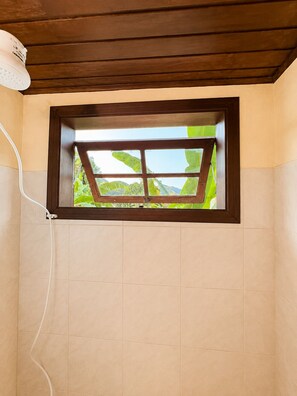 A room with a window, a white cable, and a wooden ceiling. - Charming loft with a mezzanine, 2 balconies, and just 10 minutes from the beach (são sebastião)