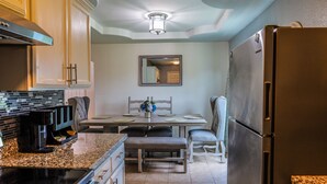 A kitchen with a dining table, chairs, a refrigerator, and a coffee maker. - Cozy Case Mena . Pet Friendly . Fiber WiFi (San Juan)