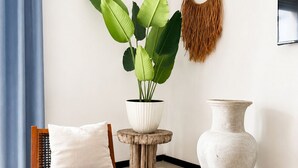 A room with a wooden bench, a potted plant, a white vase, and a woven wall hanging. - 10 guests, amazing 3-bedroom apartment in downtown Playa del Carmen (Playa del Carmen)