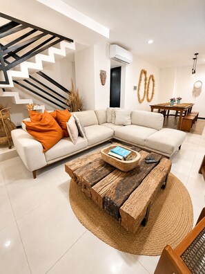A modern living room with a sectional sofa, a wooden coffee table, and a staircase. - 10 guests, amazing 3-bedroom apartment in downtown Playa del Carmen (Playa del Carmen)