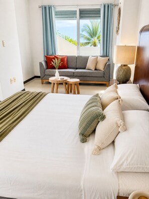A hotel room with a bed, a sofa, a small table, and a lamp. - 10 guests, amazing 3-bedroom apartment in downtown Playa del Carmen (Playa del Carmen)