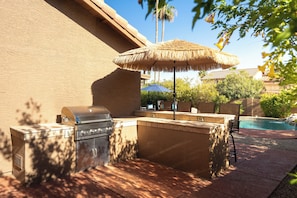 An outdoor kitchen area with a grill, a built-in sink, and a seating area with a table and chairs. - *Scottsdale Kierland*Pool*Spa*Water Fall* (Scottsdale)