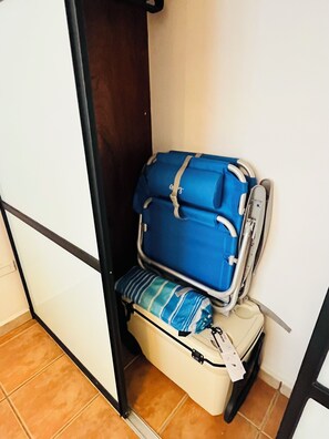 A corner of a room with a bed, a blue suitcase, and a striped pillow. - Ocean View 2-bedroom 2- bathroom apartment with AC in Rincon (Rincon)