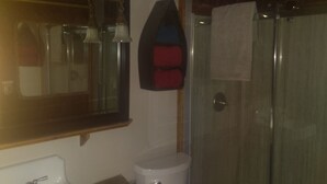 Uma casa de banho com lavatório, sanita e chuveiro.