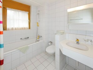 Ein Badezimmer mit einer Badewanne, Toilette und Waschbecken.