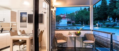 Una cocina moderna con armarios blancos y una zona de comedor con mesa y sillas.