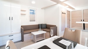 Et moderne, veloplyst rum med en sofa, et lille bord og et spiseområde.