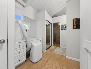 A laundry room with a washing machine, dryer, and a large mirror. - Sunset, Ocean, and Golf Course Views! (Waikoloa Village)