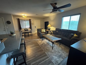 A modern living room with a sofa, coffee table, and dining area. - Route 66 River House: 8 Min to Boat Launch, Boat & Trailer Parking (Mohave Valley)