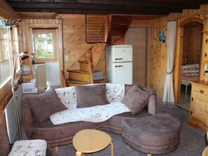 A cozy cabin interior with a sofa, ottoman, and a small table. - Föhre, (Grächen), 1420 by Interhome (Grächen)