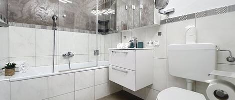 A modern bathroom with a shower, toilet, and vanity.