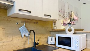 Une cuisine moderne équipée d’un évier, d’un grille-pain, d’un four à micro-ondes et d’un vase rempli de fleurs, posé sur le plan de travail.