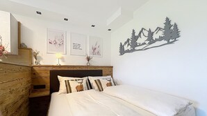 Une chambre à coucher avec un lit, une tête de lit en bois et un élément décoratif fixé au mur.