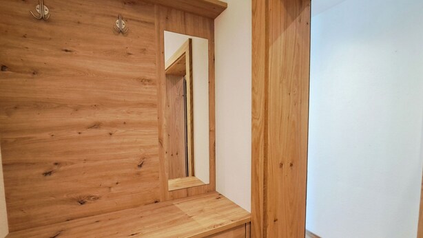 Une armoire en bois avec un miroir et un tiroir.