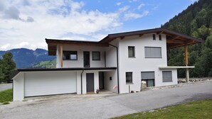 A modern two-story house with a garage, a covered porch, and a view of mountains. - Apartment Tyrol by Interhome (Auffach)