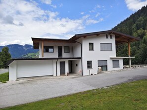 A modern two-story house with a garage, a covered porch, and a view of mountains. - Apartment Tyrol by Interhome (Auffach)