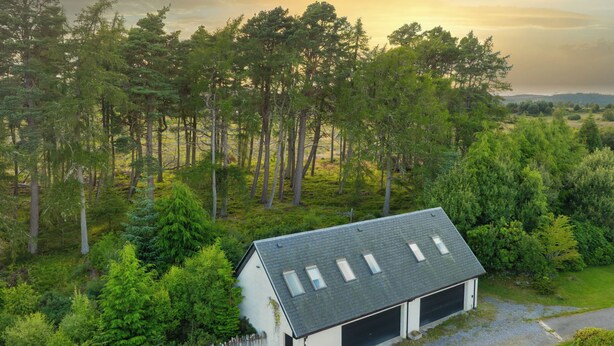 A house with a garage, surrounded by dense forest. - Bunloit Loft by Interhome (Drumnadrochit)