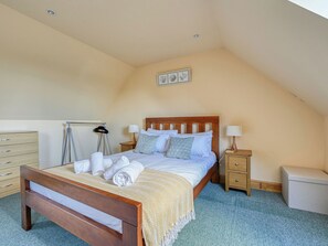 Ein Schlafzimmer mit einem hölzernen Bett, zwei Nachttischen, einem Schrank und einer Heizung.