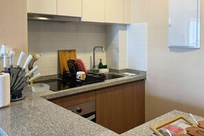 Eine kleine Küche mit Spüle, Arbeitsfläche und Holzschränken.