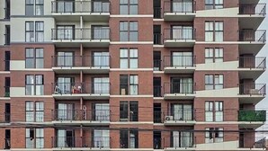 A multi-story residential building with balconies, a ground-level retail space, and a parking area. - Anime apartment in Lima (Lima)