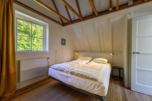 A bedroom with a bed, a window, a radiator, a door, and a small table. - Lovely Holiday Home Centrally Located in Bergen in Delightful Surroundings (Bergen)
