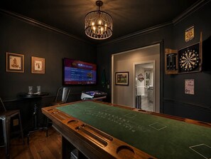 A billiards room with a pool table, a dartboard, and a television screen. - Luxury Golf•Stay Simulator•Hot Tub•PGA Golden Tee (Pinehurst)