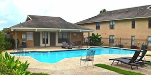 A swimming pool with lounge chairs and a covered seating area. - Near Hospitals 2 bedroom 1 bath in Baton Rouge (Baton Rouge)