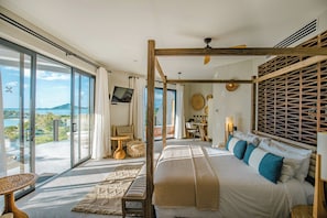 A spacious bedroom with a large bed, a wooden canopy, a view of the sea, a balcony with seating, and a television. - A Stay Worth Traveling For! Tropical Escape with Private Pool and Antigua Views! (Urlings)
