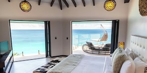 A bedroom with a large bed, a TV, and a view of the ocean. - Book Before It’s Gone! 2BR Villa with Panoramic Caribbean Views and Private Pool (Urlings)