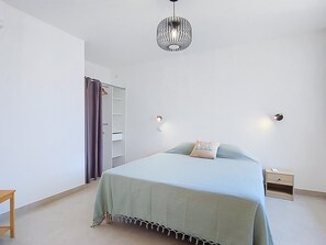 A bedroom with a bed, a wardrobe, a nightstand, and a hanging light fixture. - Maison Lou Oustaou by Interhome (Sainte Maxime)